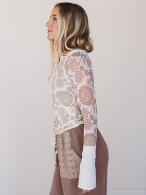 Woman wearing a floral lace top with a plain background