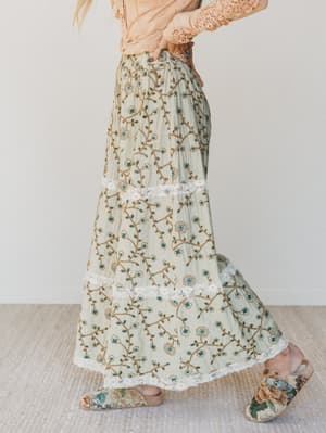 Person wearing floral pants with a plain background