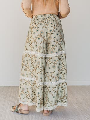 Person wearing floral pants with a plain background