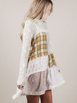 Woman wearing a white lace top with plaid and floral patterns on a beige background