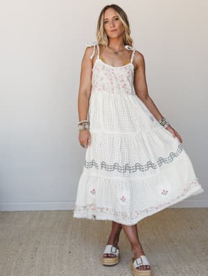 A cream midi dress with floral embroidery and eyelet texture, styled with platform espadrille sandals and stacked bracelets — the kind of outfit that feels equally at home at a bridal shower or wandering a farmers market.