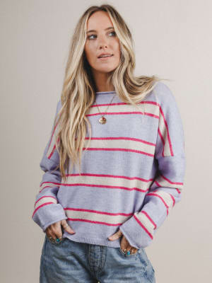 Woman wearing a striped sweater with white and red stripes on a plain background