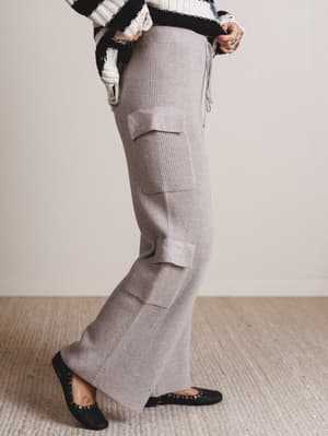 Person wearing gray cargo pants with a neutral background