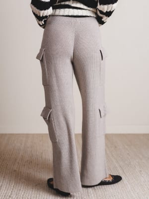 Person wearing gray ribbed pants with cargo pockets on a neutral background