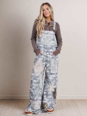 Woman wearing a patterned overalls with a plain background