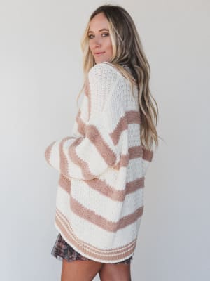 Woman wearing a striped sweater against a plain background