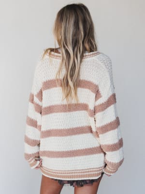 Person wearing a striped sweater with a neutral background