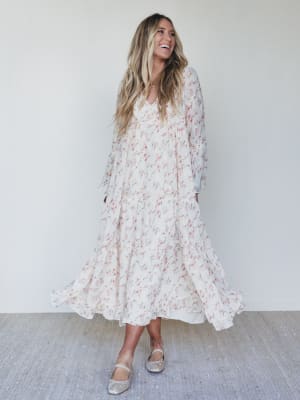Woman wearing a floral dress against a white wall
