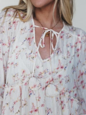 Floral dress with a tie neckline on a plain background