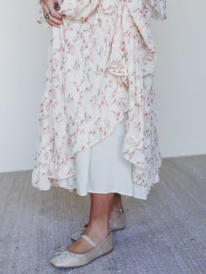 Person wearing a floral dress with a plain background