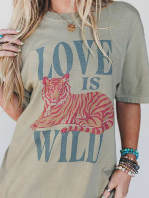 Person wearing a t-shirt with a tiger graphic and 'Love is Wild' text.