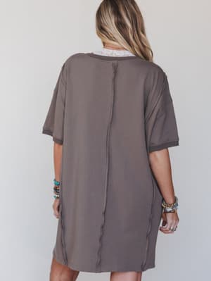 Person wearing a gray oversized t-shirt against a plain background