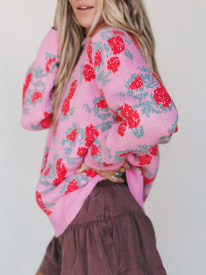 Person wearing a pink floral cardigan against a plain background