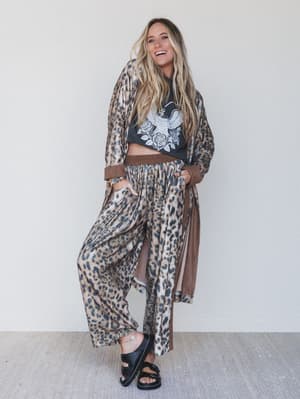 Woman wearing a leopard print outfit with a plain background