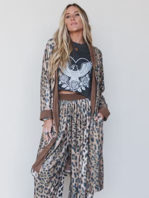 Woman wearing a leopard print outfit with a black graphic t-shirt against a white background