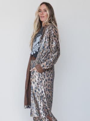 Woman wearing a leopard print dress with a plain background