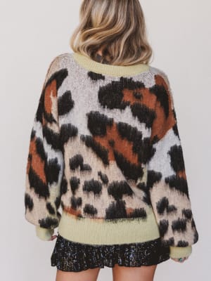 Person wearing a patterned sweater with a plain background