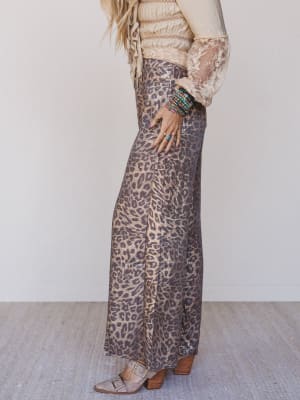 Person wearing leopard print pants with a plain background