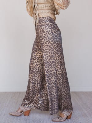 Leopard print pants worn by a person on a neutral background