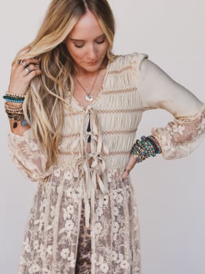 Woman wearing a floral duster with long sleeves and a white background