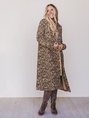 Woman wearing a leopard print coat against a plain background