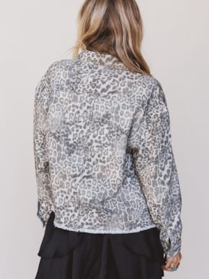 Person wearing a leopard print shirt against a plain background