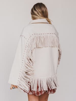 White fringed jacket worn by a person on a plain background