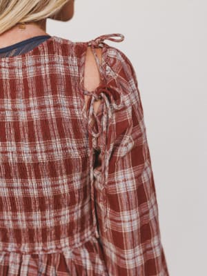 Plaid shirt with tie detail on a plain background