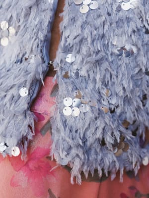 Close-up of a textured fabric with sequins on a pink background