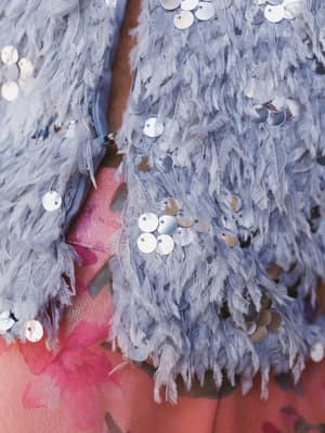 Close-up of a textured fabric with sequins on a pink background