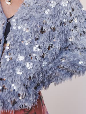 Close-up of a blue sequin jacket with a blurred background
