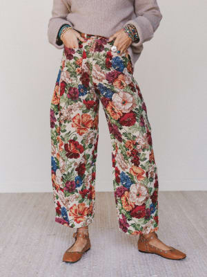 Person wearing colorful floral pants with a plain background