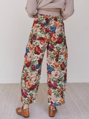 Floral patterned pants worn by a person on a neutral background