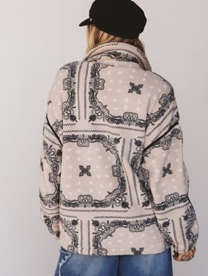 Person wearing a patterned jacket with a plain background