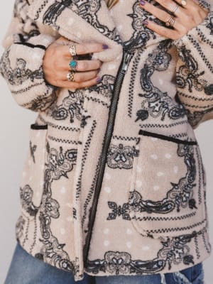 Close-up of a person wearing a patterned jacket with a white background