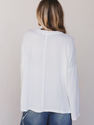 Person wearing a white blouse with a neutral background