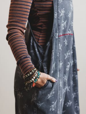 Person wearing a striped shirt and patterned jacket with visible jewelry.