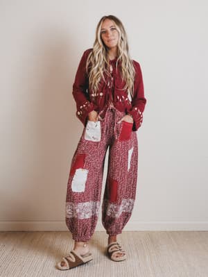 Woman wearing a red patterned outfit with a plain background