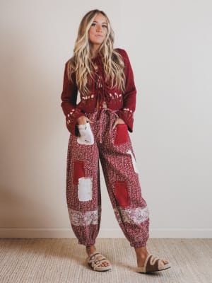 Woman wearing a red and white patterned outfit against a plain background