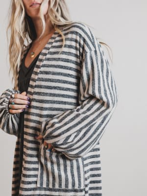 Person wearing a striped cardigan with a plain background