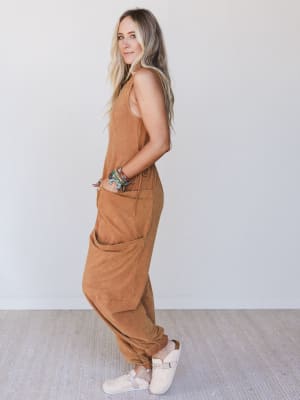 Woman wearing a brown jumpsuit against a white background