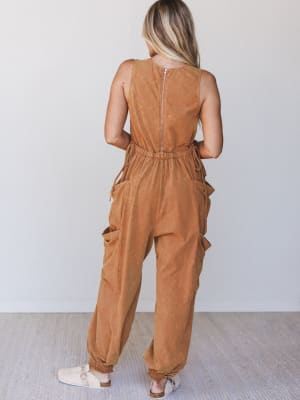 Person wearing a brown jumpsuit against a white background