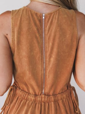 Rust colored sleeveless dress with a zipper back on a plain background