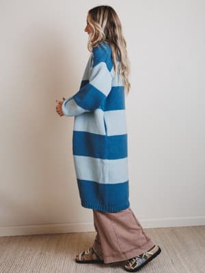 Person wearing a blue and white striped sweater against a plain background