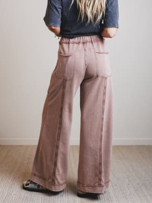 Person wearing wide-leg pants and a denim shirt against a plain background