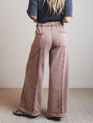 Person wearing wide-leg pants and a denim shirt against a plain background
