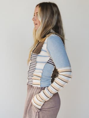 Woman wearing a striped sweater with a plain background