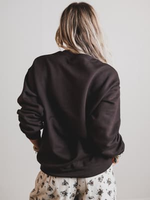Person wearing a dark brown sweatshirt with a plain background