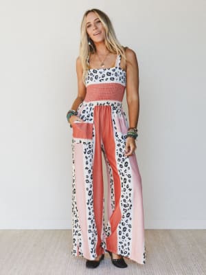 Woman wearing a colorful patterned sleeveless jumpsuit against a white background