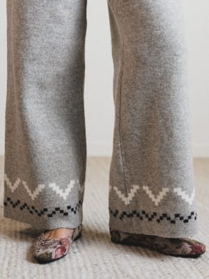 Gray pants with a patterned hem on a neutral background